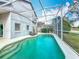 View of a screened-in pool with lounge chairs and a concrete pool deck at 2105 Mallory Cir, Haines City, FL 33844