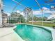 Backyard view of a screened-in pool with chaise lounge chairs and view of the lawn at 2105 Mallory Cir, Haines City, FL 33844