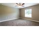 Bright, carpeted bedroom with a ceiling fan and natural light from the window at 214 Kay St, Auburndale, FL 33823