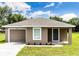 Charming single-story home with a well-manicured lawn, attached garage, and neutral color palette at 214 Kay St, Auburndale, FL 33823