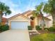 Charming single-Gathering home featuring a well-maintained front lawn and attached two-car garage at 215 Cordova Ave, Davenport, FL 33897