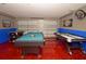 Well-lit game room boasts a pool table, foosball, air hockey, and unique red epoxy floor at 215 Cordova Ave, Davenport, FL 33897