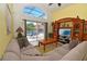 Cozy living room featuring a comfortable sofa, entertainment center, and sliding glass doors to the pool area at 215 Cordova Ave, Davenport, FL 33897