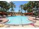 Inviting community pool surrounded by lounge chairs, palm trees, and red canopies at 215 Cordova Ave, Davenport, FL 33897