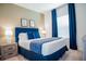 A brightly lit bedroom includes a comfortable bed, bedside tables, and light carpet flooring for a peaceful ambiance at 2166 Derwent Dr, Davenport, FL 33896