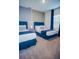 A stylish bedroom with two beds, soft carpet, and blue accents offers a cozy and inviting space for relaxation at 2166 Derwent Dr, Davenport, FL 33896