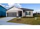 Charming single-story home features a well-manicured lawn, gray exterior, and attached two-car garage at 2166 Derwent Dr, Davenport, FL 33896
