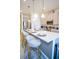Modern kitchen with a white countertop island with three seats, stainless steel appliances, and elegant pendant lighting at 2166 Derwent Dr, Davenport, FL 33896