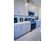 The kitchen features sleek gray cabinets, stainless steel appliances, modern countertops and light tile floor at 2166 Derwent Dr, Davenport, FL 33896