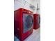 Laundry room features sleek red washer and dryer with wire shelving at 2166 Derwent Dr, Davenport, FL 33896