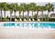 Clean community pool surrounded by palm trees and lounge chairs on a brick patio at 2166 Derwent Dr, Davenport, FL 33896