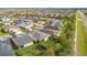 Aerial view of a well-maintained community showcases lush greenery, manicured lawns, and mature trees at 2460 Promenade Dr, St Cloud, FL 34772