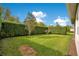 Serene backyard featuring green grass, manicured hedges, and picturesque landscaping for outdoor enjoyment at 2460 Promenade Dr, St Cloud, FL 34772