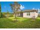 Well-maintained backyard with lush green grass, a small tree, privacy hedge and screened lanai at 2460 Promenade Dr, St Cloud, FL 34772