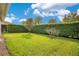 Lush backyard featuring vibrant green grass, privacy hedges, and well-maintained landscaping at 2460 Promenade Dr, St Cloud, FL 34772