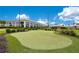 Lush putting green with manicured turf, surrounded by beautifully landscaped grounds and community buildings at 2460 Promenade Dr, St Cloud, FL 34772