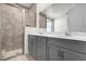 Modern bathroom with a double vanity, gray cabinetry, and a glass-enclosed shower, designed for comfort at 2468 Varenna Loop, Kissimmee, FL 34741