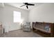 Bedroom with a wooden crib, comfortable armchair, and neutral carpet at 2468 Varenna Loop, Kissimmee, FL 34741