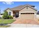 Attractive single-Gathering home with a two-car garage and manicured lawn, enhanced by a brick driveway at 2468 Varenna Loop, Kissimmee, FL 34741