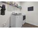 Bright laundry room featuring a modern washer and dryer, complemented by shelving and a convenient wall calendar at 2468 Varenna Loop, Kissimmee, FL 34741