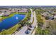 Aerial view of a gated community entrance, a scenic pond with a fountain, and palm-lined streets at 2814 Plymouth Pl, Kissimmee, FL 34741