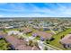 Expansive aerial view of a residential community with well-maintained lawns, landscaping, and a central pond at 2814 Plymouth Pl, Kissimmee, FL 34741