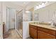 Bright bathroom featuring a glass shower, granite countertop, and vanity with dark wood cabinets at 2814 Plymouth Pl, Kissimmee, FL 34741