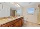 Bathroom featuring double sinks, wood cabinets, granite countertops, and a tiled shower at 2814 Plymouth Pl, Kissimmee, FL 34741