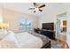 Bright bedroom with a ceiling fan, desk, television, and a sliding door to the kitchen at 2814 Plymouth Pl, Kissimmee, FL 34741