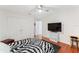 Bedroom with hardwood floors, ceiling fan, zebra print comforter, TV, and a double door closet at 2814 Plymouth Pl, Kissimmee, FL 34741