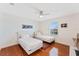 Bedroom with hardwood floors and two white beds under a ceiling fan with natural lighting at 2814 Plymouth Pl, Kissimmee, FL 34741