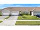 Charming townhome exterior with a well-manicured lawn and a paved driveway to a two-car garage at 2814 Plymouth Pl, Kissimmee, FL 34741