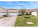 Charming single-story home featuring a red tile roof, brick driveway, and well-manicured lawn with lush landscaping at 2814 Plymouth Pl, Kissimmee, FL 34741