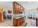 Kitchen featuring wood cabinets, granite countertops, stainless steel appliances, and tile flooring at 2814 Plymouth Pl, Kissimmee, FL 34741
