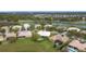 An aerial view of a neighborhood showcasing lush landscaping, serene water features, and tile roof homes at 3010 Winding Trl, Kissimmee, FL 34746