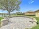 Backyard showcasing circular brick paver patio, lush lawn, landscaping and community view at 3010 Winding Trl, Kissimmee, FL 34746