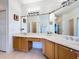 Bright bathroom features a spacious vanity with dual sinks, large mirror and a tiled floor at 3010 Winding Trl, Kissimmee, FL 34746