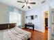 Cozy bedroom features wood floors, ceiling fan, tv and large window at 3010 Winding Trl, Kissimmee, FL 34746