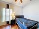 Cozy bedroom features wood floors, ceiling fan and lamp at 3010 Winding Trl, Kissimmee, FL 34746