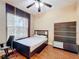 Cozy bedroom features wood floors, ceiling fan and large window at 3010 Winding Trl, Kissimmee, FL 34746