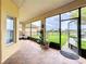Screened-in lanai with brick flooring and views of a tranquil backyard and lake at 3010 Winding Trl, Kissimmee, FL 34746