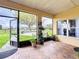 Screened-in lanai with brick flooring and views of a tranquil backyard and lake at 3010 Winding Trl, Kissimmee, FL 34746