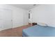 Carpeted bedroom with a blue bed, white walls, and white trim around a door and a walk through to another space at 3188 Serendipity Way, Davenport, FL 33896
