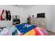 Well-lit bedroom with a patterned blanket, dresser, mirror, and ample closet space at 3188 Serendipity Way, Davenport, FL 33896