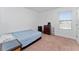 Simple bedroom with a twin bed, dresser, and a bright window at 3188 Serendipity Way, Davenport, FL 33896