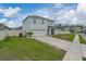 A beautifully landscaped lawn surrounds this two-story house with an attached two-car garage at 3188 Serendipity Way, Davenport, FL 33896