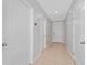 Inviting hallway with tile flooring, neutral walls, and white doors leading to various rooms at 3188 Serendipity Way, Davenport, FL 33896