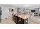 An open kitchen with stainless steel sink and dark cabinets leads to the dining and living area at 3188 Serendipity Way, Davenport, FL 33896