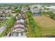 Aerial view of a residential neighborhood with green fields, blue sport courts, and well-maintained homes at 3203 Rio Grande Trl, Kissimmee, FL 34741