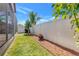 Well-maintained backyard featuring lush grass, vibrant plants, and a white privacy fence at 3471 Julius Estates Blvd, Winter Haven, FL 33881